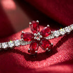 Jewelry with red gemstones and white stones on a red fabric background